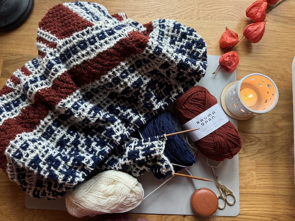 A picture of a wooly shawl in the progress of beeing knitted.